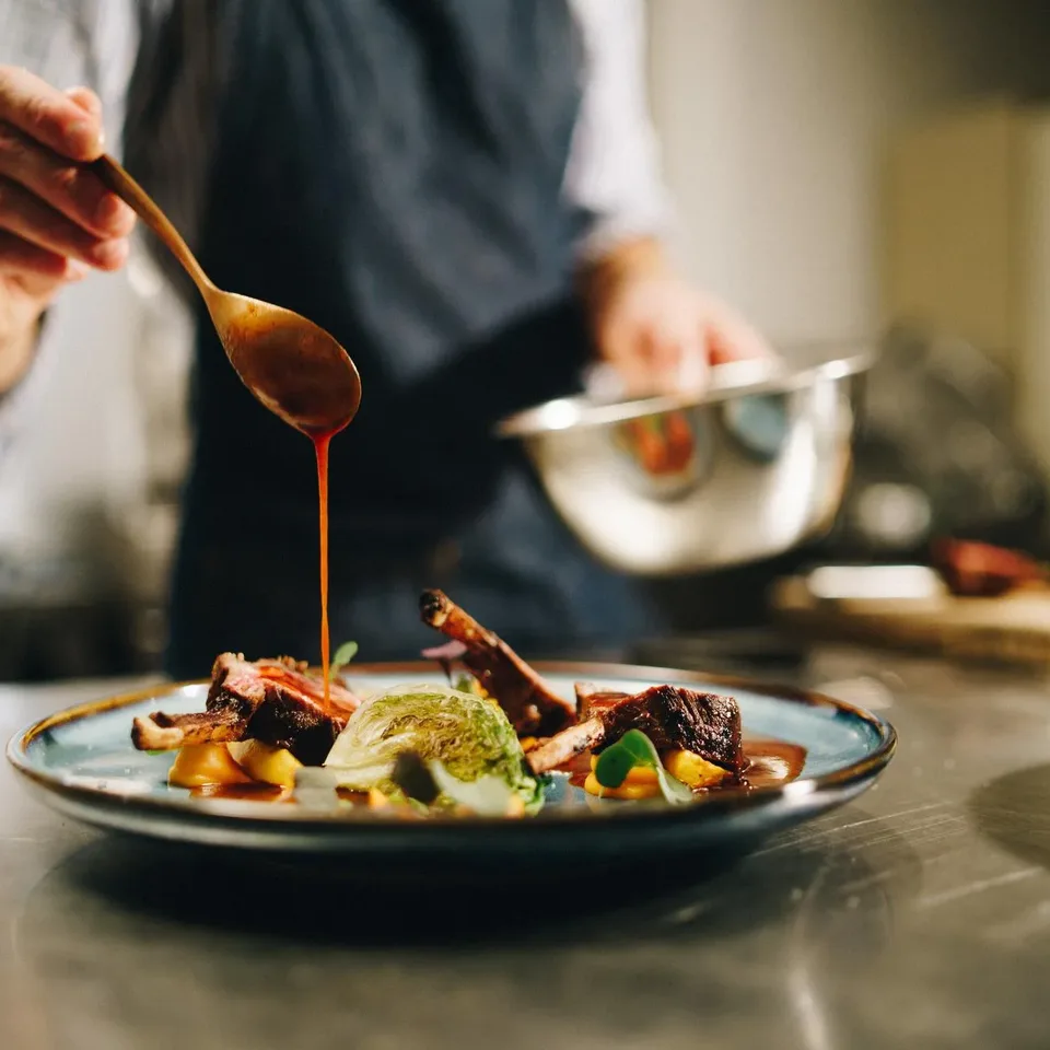 Chef dressant une assiette raffinée en cuisine professionnelle