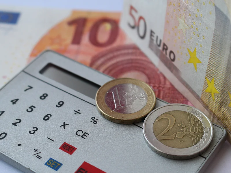 Calculatrice, billets et pièces en euros, illustration de l'article sur le salaire d'apprenti